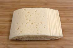 a block of cheese sitting on top of a wooden table