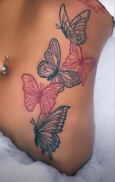 a woman's stomach with three butterflies on it and the bottom half of her stomach