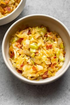 two white bowls filled with food on top of a table