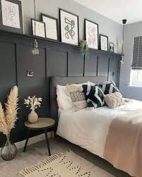 a bed sitting in a bedroom next to a window with pictures on the wall above it