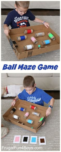 a boy is playing with some sort of ball maze game that he made out of cardboard boxes