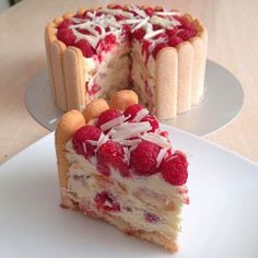 a piece of cake with raspberries and coconut on top