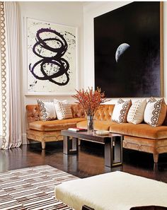 a living room filled with furniture and a large painting on the wall above it's headboard