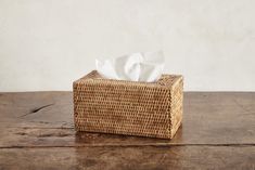 a tissue dispenser sitting on top of a wooden table