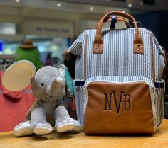 a stuffed elephant sitting next to a backpack