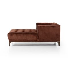 a brown couch sitting on top of a white floor next to a wooden legrest