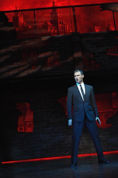 a man in a suit and tie standing on stage