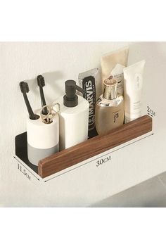 a bathroom shelf with two toothbrushes, soap and lotion bottles on it