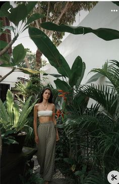 a woman standing in front of some plants