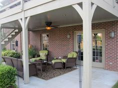 an outdoor patio with chairs and tables under a pergolated roof next to a brick building