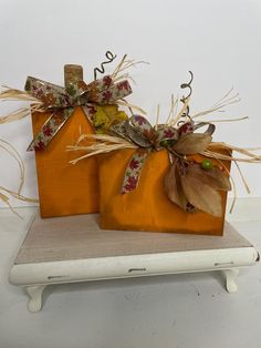 two small pumpkins are sitting on a shelf