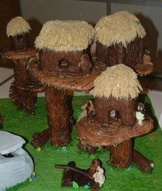 there are many small houses made out of wood and grass on the table, with animals around them