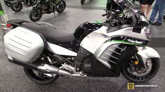 a silver motorcycle parked on top of a floor next to other motorcycles in a room