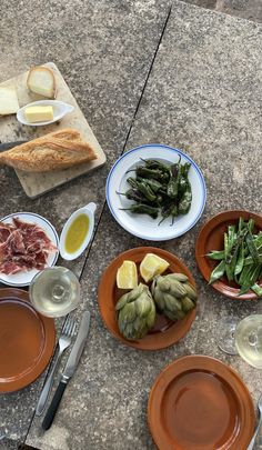 an assortment of food sitting on top of a table next to wine glasses and utensils