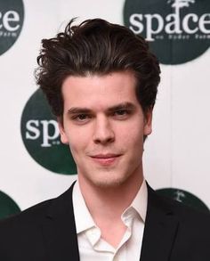 a young man in a black suit and white shirt