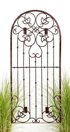 an iron gate with grass in front of it