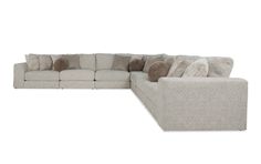 a large sectional couch with pillows on the top and bottom corner, in front of a white background