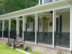 the front porch of a house with black iron railings