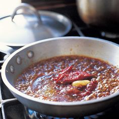 a pot filled with chili sitting on top of a stove