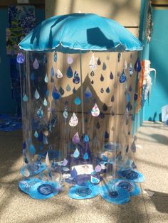 an umbrella made out of plastic cups and paper plates with rain drops on the inside