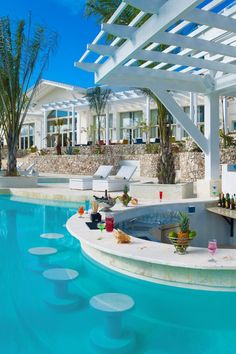 an outdoor swimming pool with chaise lounges next to it