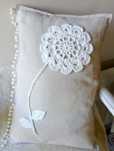 a white pillow with a crocheted flower on it