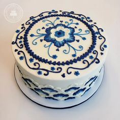 a blue and white cake with an intricate design on the top is ready to be eaten