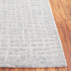 a light blue rug on a wooden floor