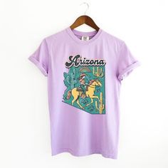 This trendy oversized unisex short sleeve graphic tee from Simply Sage Market is sure to make a great addition to any wardrobe. These tees are true to size. For a stylish oversized look, size up. Short Sleeve Sage Green Oversized Shirt, Lavender Graphic Cotton Tee, Lavender Graphic Print Crew Neck T-shirt, Cheap Lavender Women's T-shirt, Cheap Women's Lavender T-shirt, Arizona State, Unisex Shorts, Dye T Shirt, Shirt Outfit