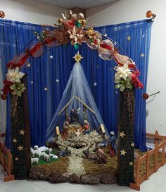 a nativity scene is displayed in front of a blue drape with stars on it