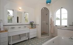 a large bathroom with two sinks and a bathtub