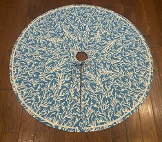 a blue and white round table on wooden flooring with an intricate design in the center