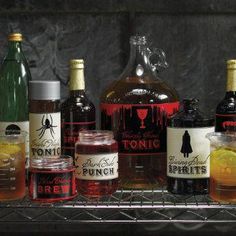 several bottles of alcohol sitting on top of a metal shelf next to glasses and lemons