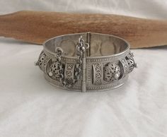 "This vintage Berber Tuareg bangle is a real stunner.  Beautifully handworked it has eight intricate filigree silver domes alternating with 10 silver \"bridges\". The work in this piece is exquisite. Each dome is topped with a silver drop, the \"bridges\" are carved with botanical curls and the edges of the bangle are decorated with a fine silver wire twist and superfine dropwork. The bangle is firmly hinged and locks with a pin and barrel with chain. Simultaneously light but strong, this is a truly unique piece of very high workmanship. Weight: 49.1 grams Shipping : DHL EXPRESS 🙂" Traditional Filigree Cuff Bracelet Bangle, Traditional Filigree Bracelets For Festivals, Traditional Round Cuff Bracelet With Intricate Design, Traditional Filigree Cuff Bangle Bracelet, Vintage Bracelets With Intricate Design For Festivals, Traditional Sterling Silver Bracelet With Intricate Design For Festivals, Ornate Ceremonial Bracelet With Intricate Design, Handmade Ornate Bangle, Ornate Sterling Silver Bracelet For Wedding With Intricate Design