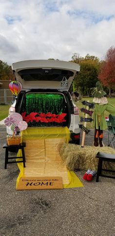 the back of a van parked in a parking lot with hay bales and decorations