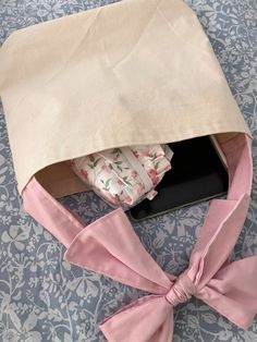 a pink bow tied around an open box