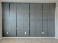 an empty room with gray walls and carpet