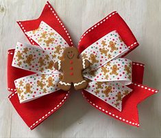 "GINGERBREAD MAN BOW WITH SMALL DOTS **The size of the pictured bow is 5 inches, but can be ordered in other sizes with the same shipping time. Hair bows may be made with a french barrette, an alligator clip (as shown), or a hair tie. ITEM DETAILS: *Ribbon Type: Base Layer- red with white stiching Top Layer-gingerbread men with dots Embellished with a gingerbread man *BOW DIMENSIONS: 4.5\", 5\", or 6\" *CLASP: French Barrette or Alligator Clip *Edges are heat sealed to prevent fraying *Assembled Turkey Hair Bow, Thanksgiving Hair Bows, Woman Costumes, Disney Hair Bows, Vintage Christmas Sweaters, Disney Hair, Bow Ideas, Fabric Hair Bows, Christmas Hair Bows