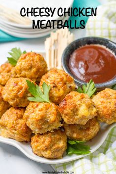 a white plate topped with fried meatballs next to a bowl of ketchup