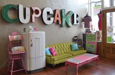 a living room filled with furniture and letters on the wall above it that says cupcake