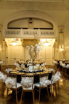 the tables are set up for a formal function with black and white decorations on them