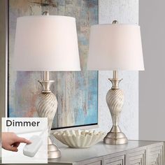 two lamps sitting on top of a dresser next to a mirror and lamp shade with the word dimmer above it