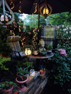 an umbrella is open in the middle of a garden with potted plants and lights