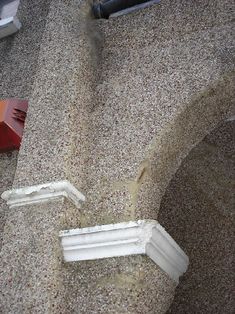 the corner of a building with some white paint on it's walls and floor