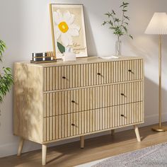 a wooden dresser sitting next to a lamp on top of a hard wood floor in a living room