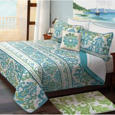 a bed with blue and green comforters in a bedroom