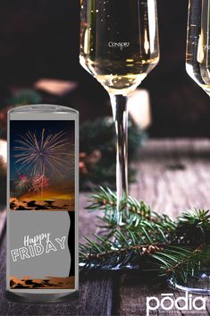 two glasses of wine are sitting next to each other on a table with pine branches