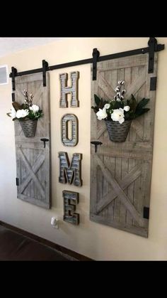 two wall hangings with flowers in them and the word home spelled out on them