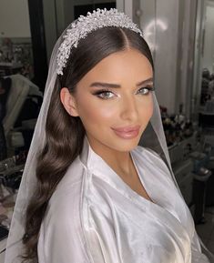 a woman wearing a bridal veil and tiara in a hairdresser shop