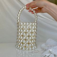 This handmade pearl bucket bag, designed to add elegance to your special occasions, dazzles with its pearl bead details. Whether paired with a wedding gown or used to complete your evening ensemble, this bag will always make you feel chic and special. Features: -Meticulously crafted by hand, with every detail delicately executed. -Made with high-quality pearl beads, exuding elegance with every touch. -Offers the option of shoulder or hand carrying thanks to its adjustable chain strap. -Includes White Pearl Bag With Pearl Chain, White Bags With Pearl Chain, White Pearl Shoulder Bag With Pearl Handle, Cream Bucket Shoulder Bag With Pearl Handle, White Pearl Handle Shoulder Bag, Formal Bucket Shoulder Bag With Pearl Handle, White Evening Bag With Pearl Handle, Formal Pearl White Pearl Shoulder Bag, Handheld Pearl Shoulder Bag With Pearl Handle